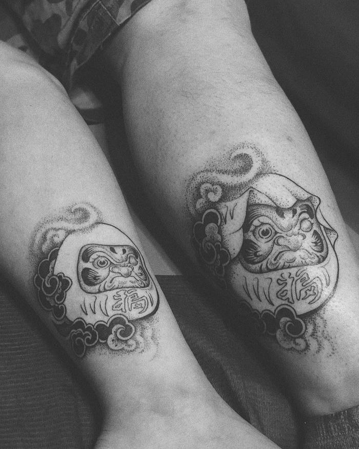 Hình xăm búp bê Daruma đen trắng ở hai chân