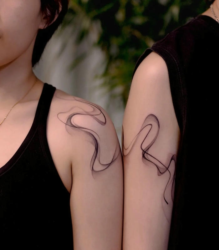 Hình xăm cặp đôi đường cong trừu tượng trên bắp tay