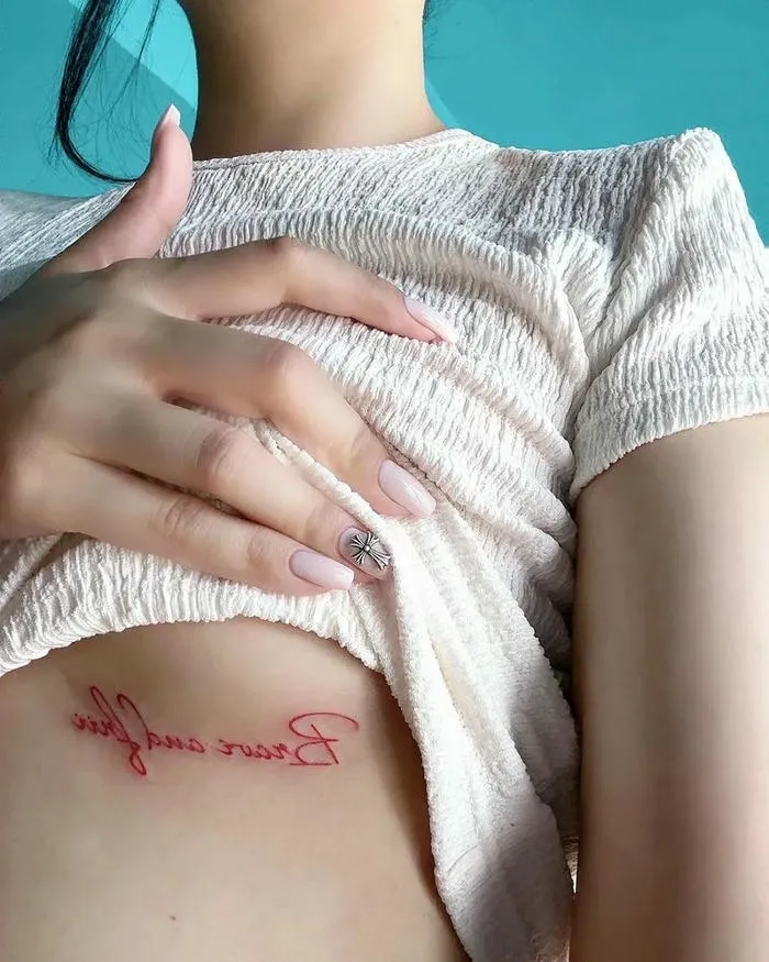 Hình xăm vùng kín dòng chữ đỏ nghệ thuật bên sườn