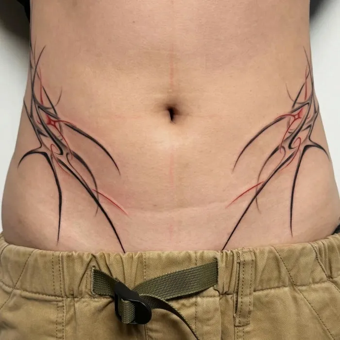 Tattoo bụng dưới hoa văn gai góc đen đỏ ấn tượng