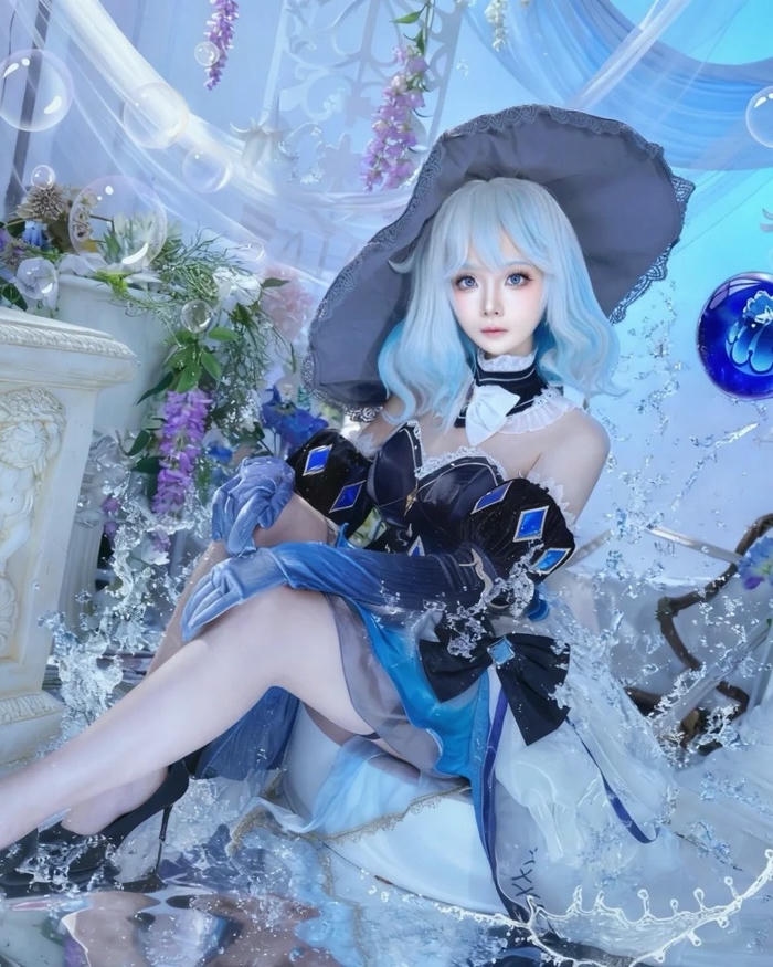 Ảnh Furina cosplay tạo dáng dịu dàng bên khóm hoa xanh