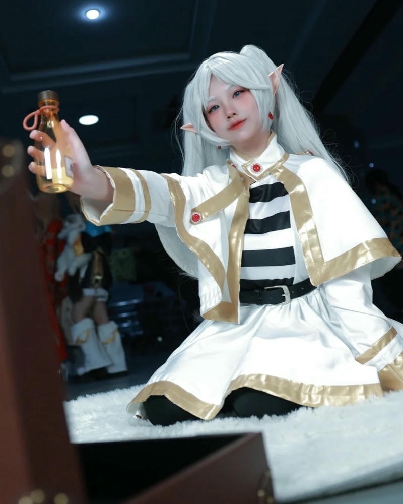 Ảnh cosplay frieren ngồi đọc sách dưới gốc cây cổ thụ