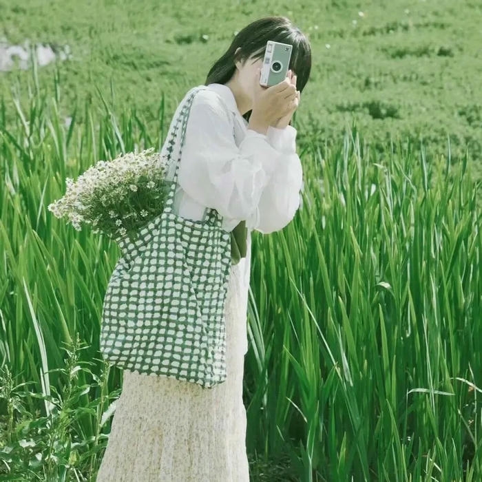 Ảnh gái xinh che mặt đứng giữa đồng cỏ xanh