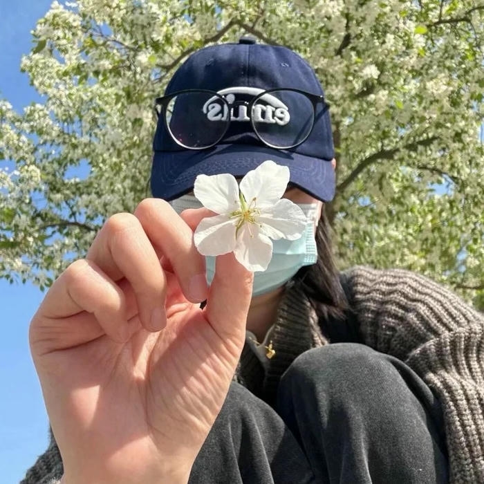 Avatar nữ che mặt bằng bông hoa nhỏ trước biển