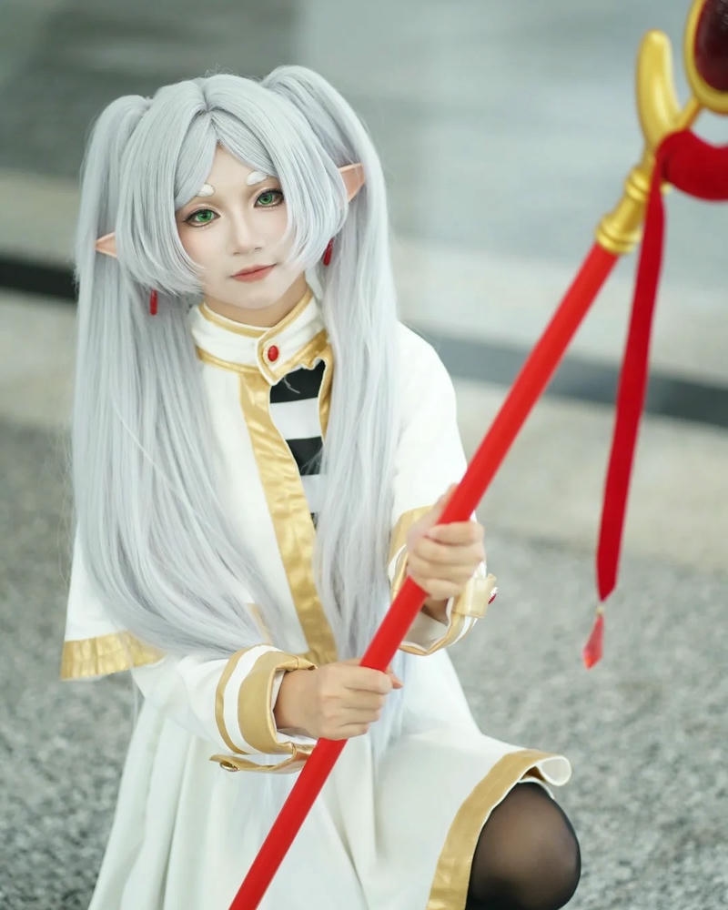 Cosplay Frieren váy trắng cầm bánh mì ăn sáng