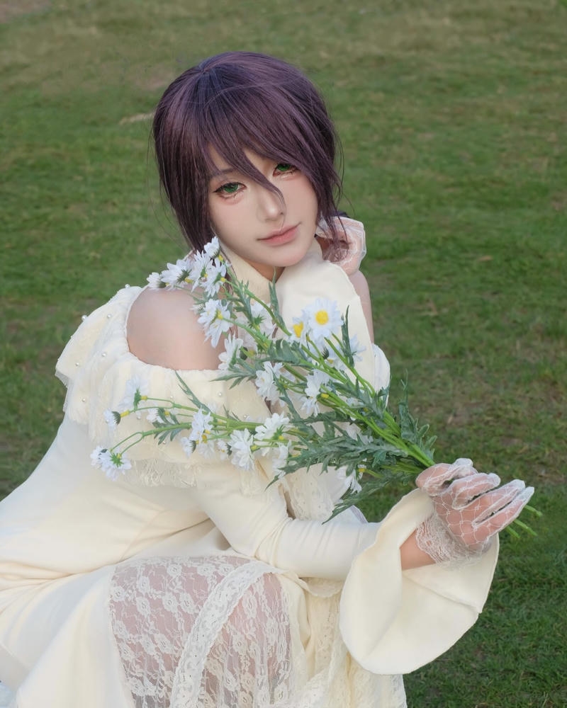 Cosplay anime nữ tóc nâu váy trắng ngồi trên cỏ xanh