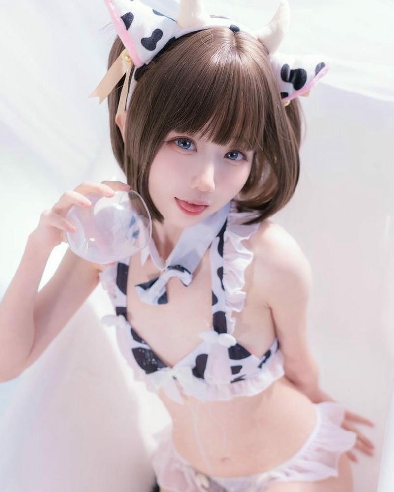 Cosplay bò sữa quỳ gối trên nền trắng tinh khôi