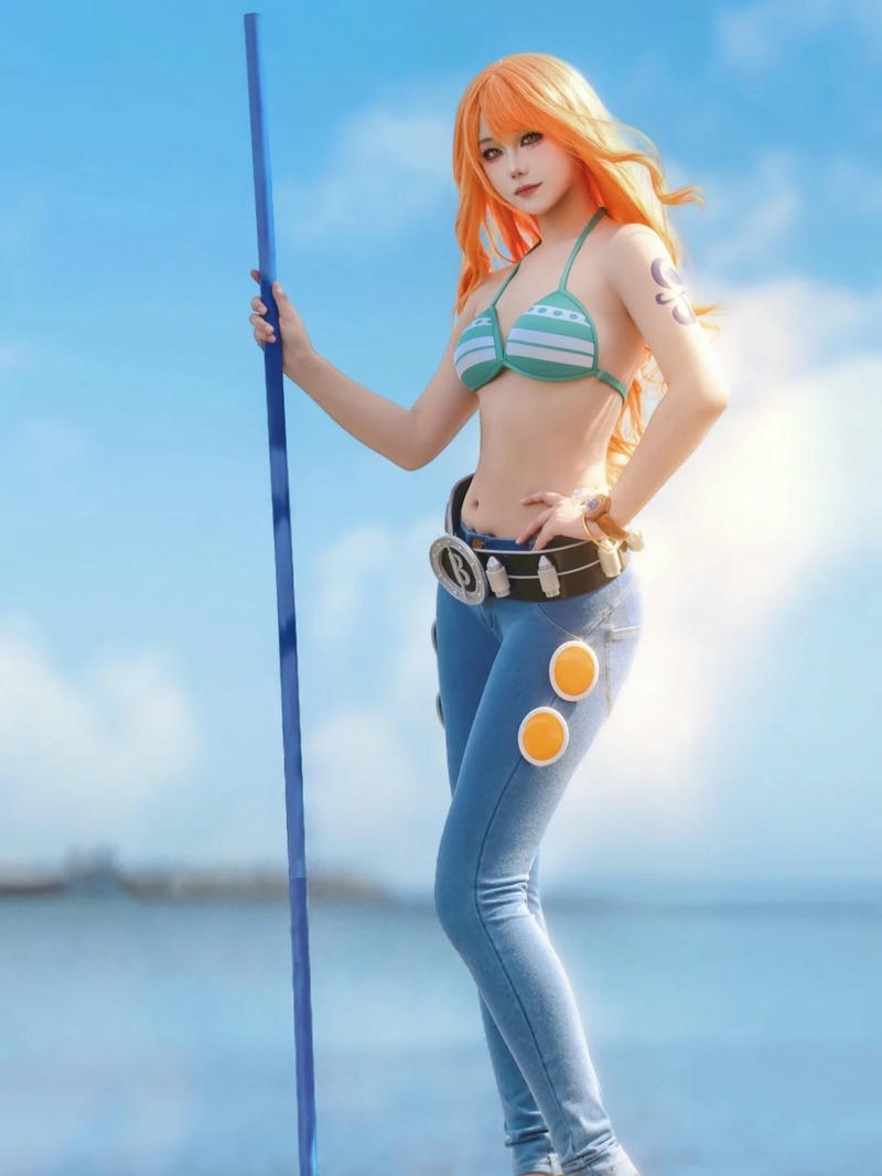 Cosplay nami đứng trên bãi biển cầm gậy khí hậu xanh