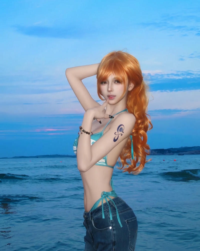 Cosplay nami mặc bikini quần jean đứng trước biển xanh