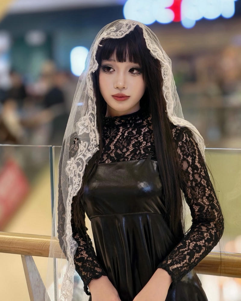 Cosplayer nữ mặc váy đen đội khăn voan lưới bí ẩn
