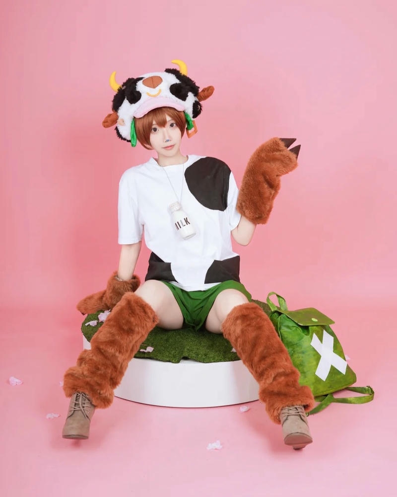 Hóa trang bò sữa ngồi ghế hồng cầm gấu bông