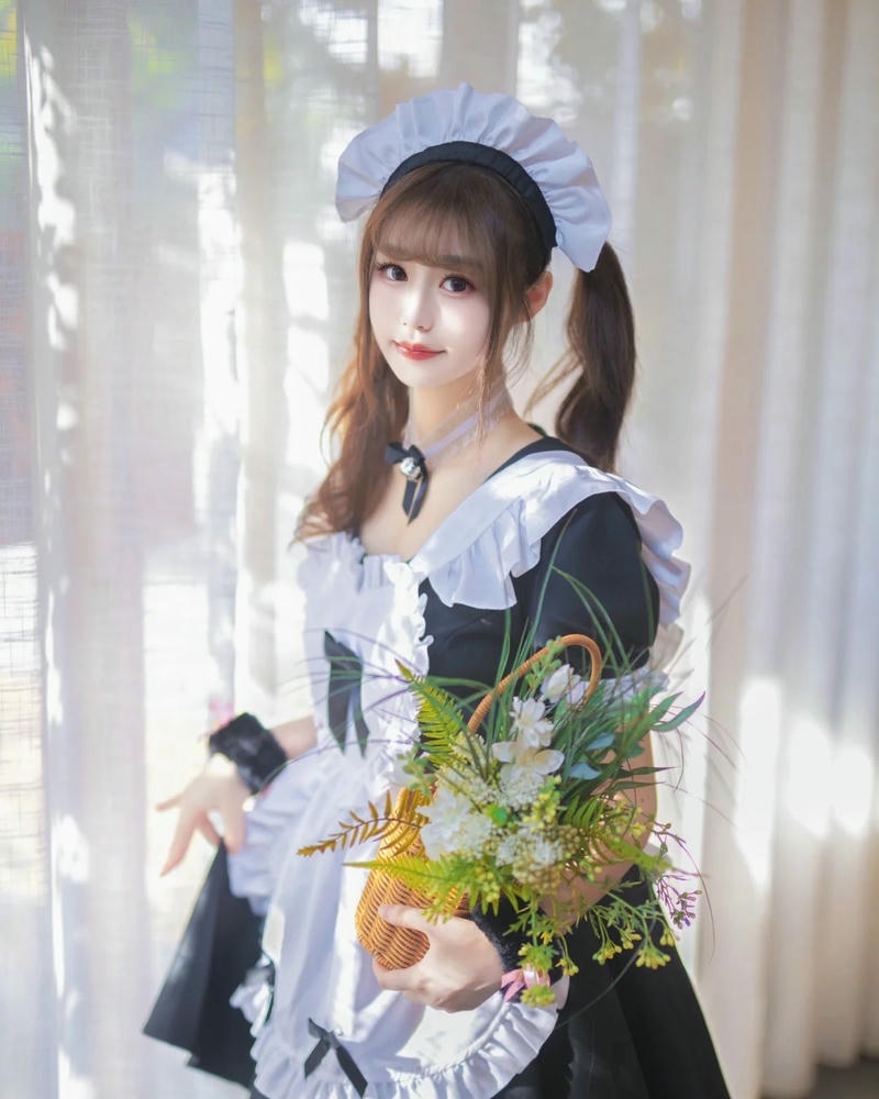 Hóa trang hầu gái cầm hoa đứng bên rèm cửa trắng