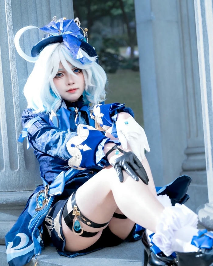 Thủy thần Furina cosplay chống cằm suy tư bên cột đá