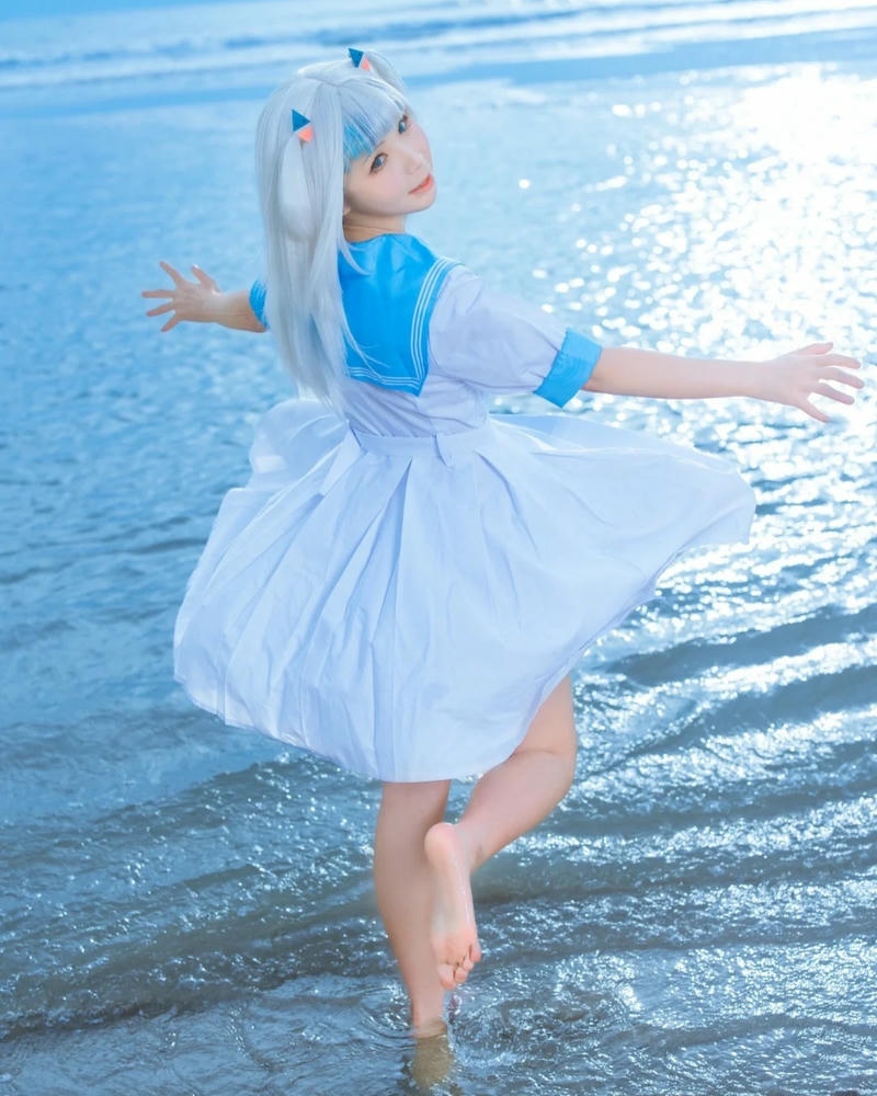 Yaoyaoqwq gawr gura cosplay đứng trước biển xanh nắng vàng rực