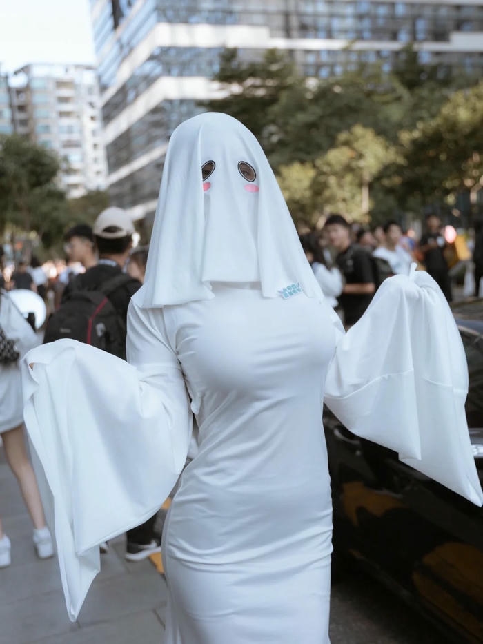 Cosplay Halloween ma trùm chăn trắng đi giữa phố đông