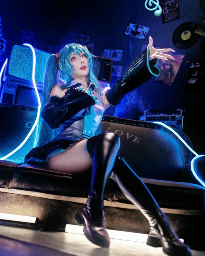 Cosplay Miku mặc đồ đua xe cầm dù đứng tạo dáng
