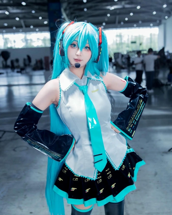 Cosplay Miku mặc váy đồng phục xám đứng hát say sưa
