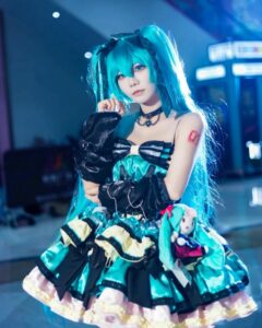 Cosplay Miku ngồi bệt trên sàn nhà đọc sách chăm chú