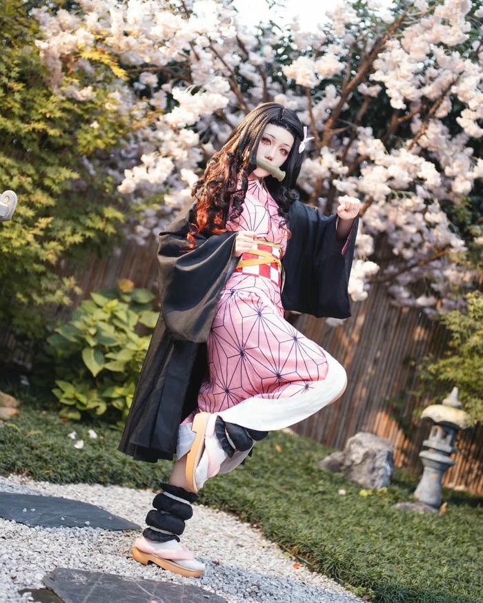 Cosplay Nezuko đứng dưới tán cây hoa anh đào rực rỡ