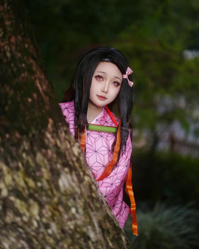 Cosplay Nezuko nấp sau thân cây nhìn lén dễ thương