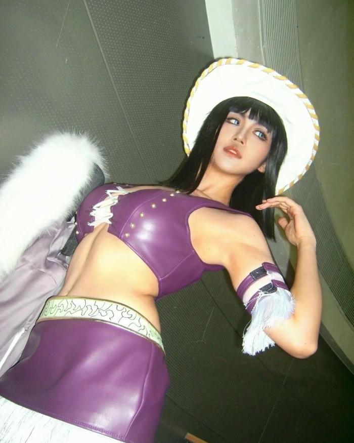 Cosplay Robin mặc đồ tím bóng đội mũ cao bồi trắng