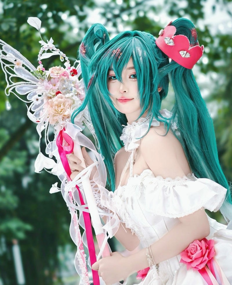 Cosplayer nữ tóc xanh cầm trượng phép thuật hoa hồng