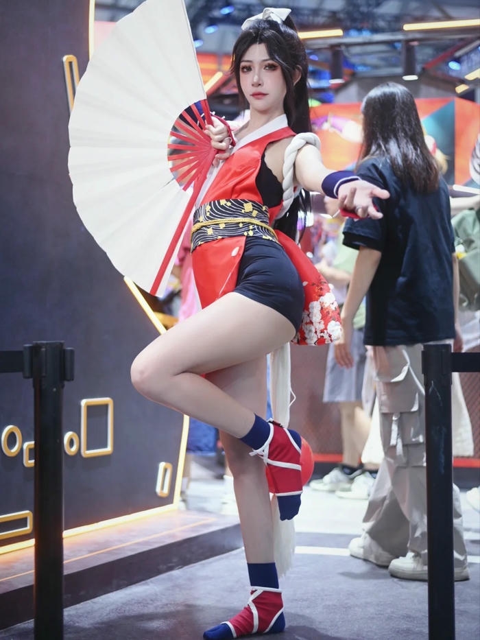 Mai Shiranui cosplay đứng một chân cầm quạt trắng to lớn