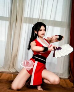 Mai Shiranui costume quỳ gối trên sàn nhà cầm quạt trắng