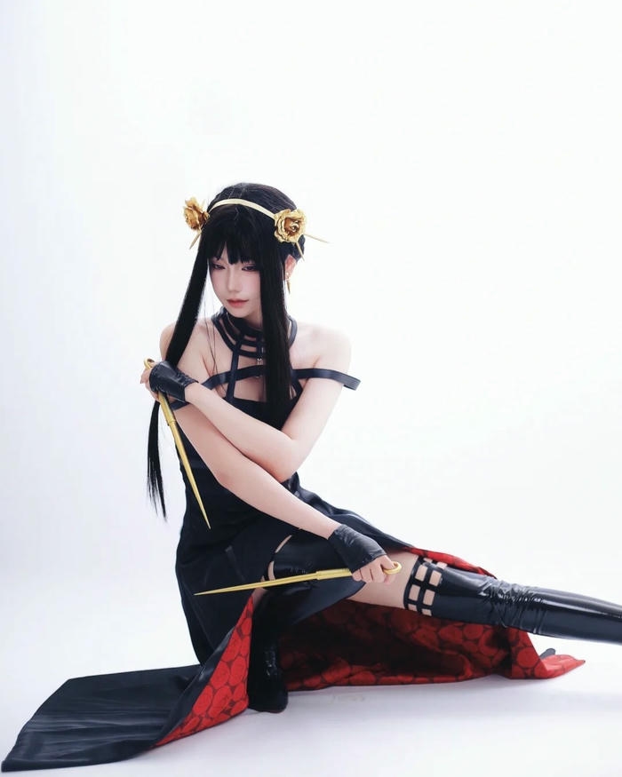 Yor Briar ngồi bệt xuống sàn tạo dáng váy xẻ tà