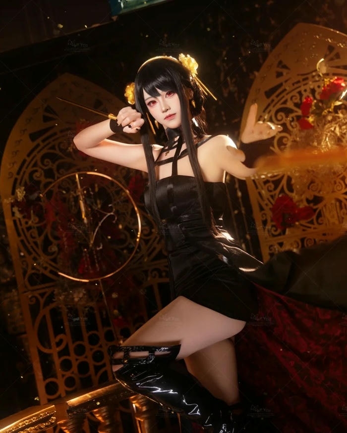 Yor Forger cosplay ngồi bắt chéo chân trên ghế vàng quyền lực