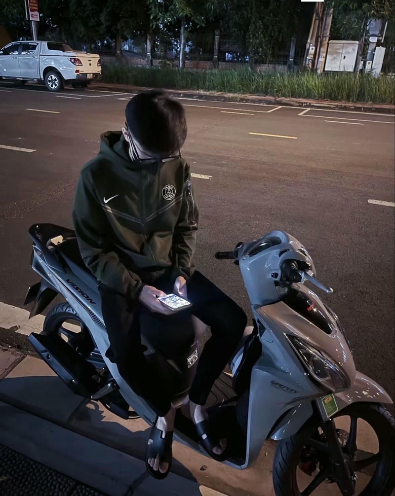 Chàng trai cá tính ngồi trên xe máy giữa phố kiểu boy phố