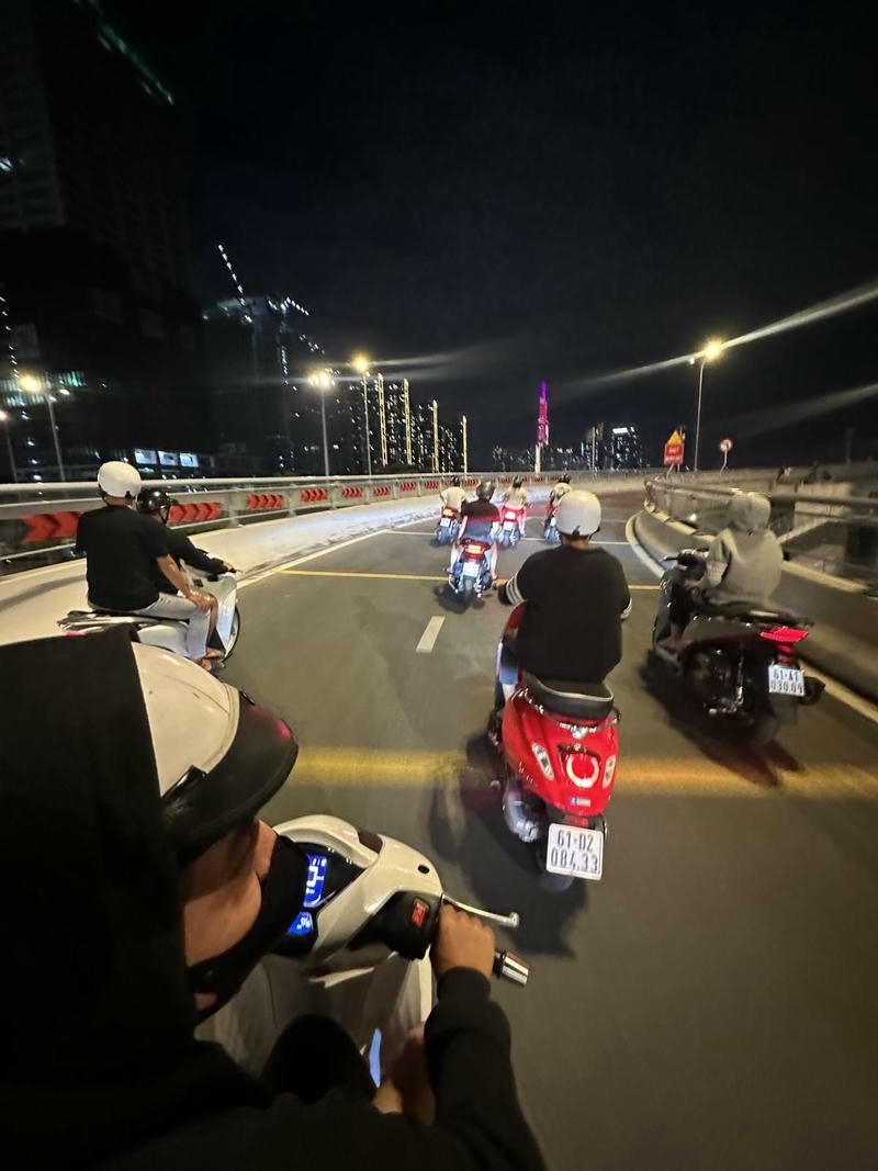 Chàng trai trẻ ngồi trên xe máy giữa phố mang phong cách cá tính