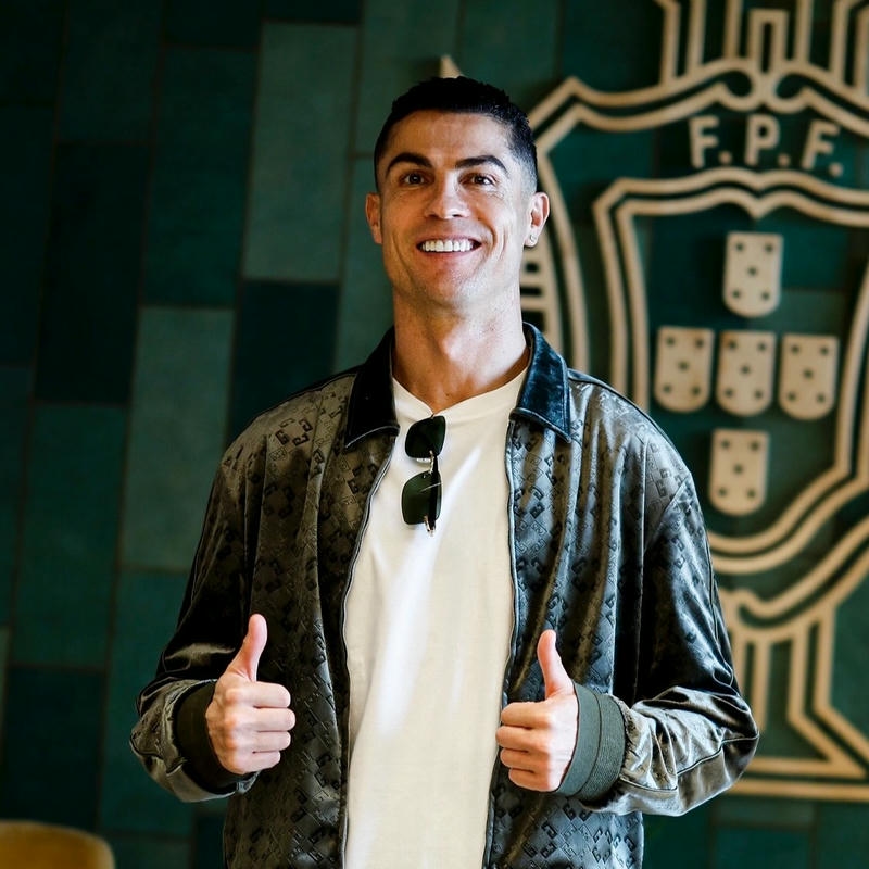 Hình ảnh huyền thoại bóng đá mặc áo khoác giơ tay