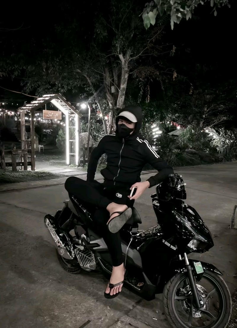 Nam sinh ngồi trên xe máy ngoài đường với phong cách boy phố