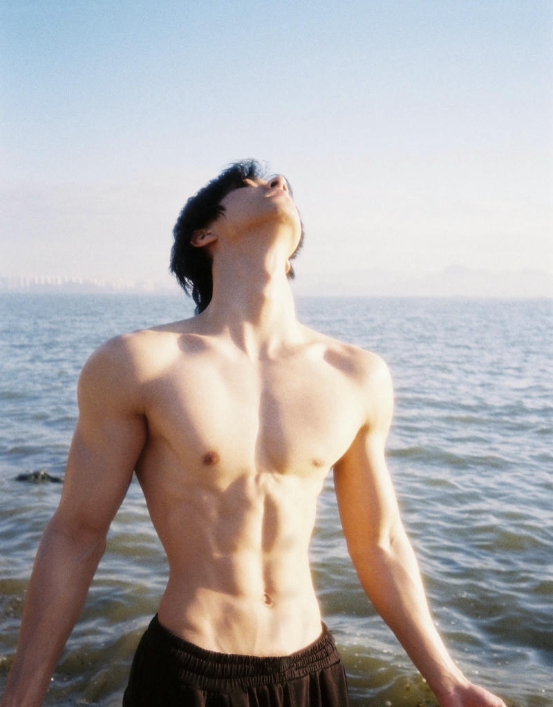 Chàng trai với cơ bụng rõ nét che mặt